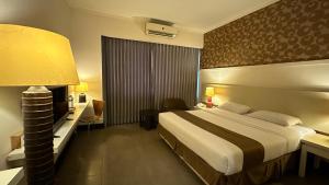 Rúm í herbergi á Bali World Hotel