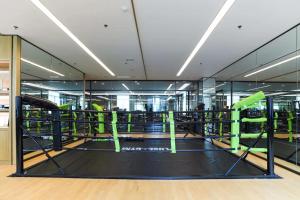 a gym with green equipment in a building at Mövenpick by Accor Binjiang Nanjing in Nanjing