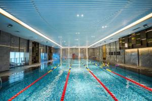 a large swimming pool in a large building at Mövenpick by Accor Binjiang Nanjing in Nanjing