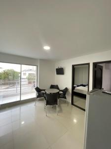 ein Wohnzimmer mit einem Tisch, Stühlen und einem Bett in der Unterkunft Hotel Fundacooedumag Rodadero in Santa Marta