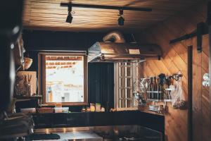 a kitchen with wooden walls and a window and a counter at Slow Island Hostel in Green Island