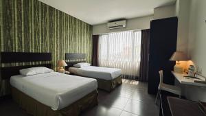 Rúm í herbergi á Bali World Hotel