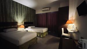 Rúm í herbergi á Bali World Hotel