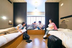 un grupo de mujeres sentadas en camas en una habitación en COGO TENNOJI en Osaka