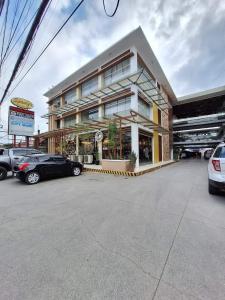 un edificio con coches estacionados frente a él en CF Haven - Resort Living Condo w/ Balcony at Bamboo Bay, en Mandaue