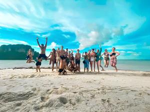 a group of people jumping on the beach at KOKO Party Hostel 18-40 in Ao Nang Beach