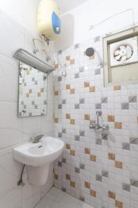 a white bathroom with a sink and a mirror at Hotel Global inn Hussainganj Lucknow in Lucknow
