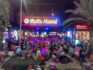 een menigte mensen die in stoelen voor een gebouw zitten bij KOKO Party Hostel in Ao Nang Beach