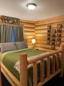 een slaapkamer met een bed in een blokhut bij Hawthorne cabin in Pine Glen