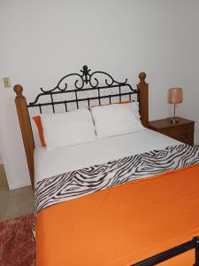 Cama naranja con edredón blanco y negro en Encharted at Winchester 2Bedrooms en Kingston