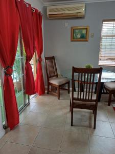 sala de estar con cortinas rojas, mesa y sillas en Encharted at Winchester 2Bedrooms en Kingston