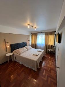 Un dormitorio con una cama grande y suelo de madera. en Apartamento en el Corazón de Mendoza, en Mendoza