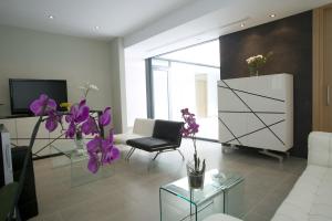 a living room with a couch and purple flowers at Hotel Spa Niwa in Brihuega