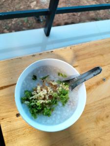 un tazón de sopa con una cuchara en una mesa en สวนไร่รุ่งอรุณ en Ban Na Pa Paek