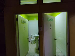 two stalls in a bathroom with a toilet and green lights at CASA EN LOS VERDES in Iquique