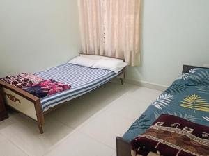 a small bedroom with a bed and a window at Chikmagalur cool stay in Chikmagalūr