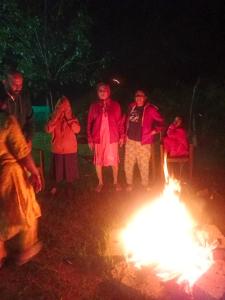a group of people standing around a bonfire at night at Chikmagalur cool stay in Chikmagalūr