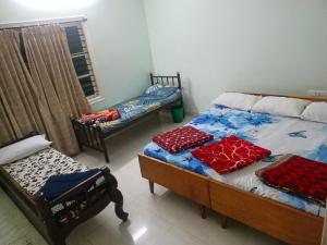 a bedroom with two beds and two chairs in it at Chikmagalur cool stay in Chikmagalūr