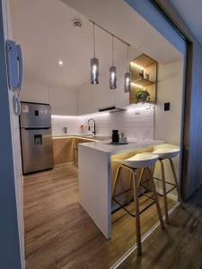 a kitchen with a counter and a stove and a refrigerator at DEPARTAMENTO KILLA HUATANA in Cusco
