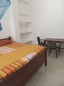 1 dormitorio con 1 cama, mesa y sillas en Sena Home, en Ambalangoda