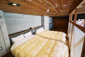 2 camas en una habitación con techos de madera en 「まちの隠れ家ペントハウス」ロフトベッド付き！｜ STAY UWU 003 Penthouse, en Kochi
