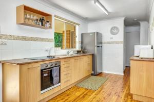 a kitchen with a sink and a refrigerator at Avalon 2 in Nambucca Heads