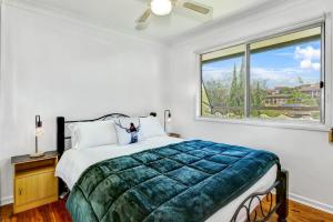 a bedroom with a large bed and a window at Avalon 2 in Nambucca Heads