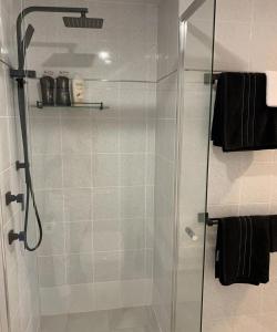 a bathroom with a shower with a glass door at Ocean Spray Sawtell in Sawtell