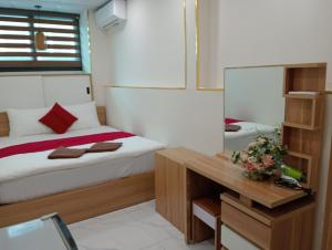 1 dormitorio con cama y escritorio con espejo en Sophie hotel, en Hanói