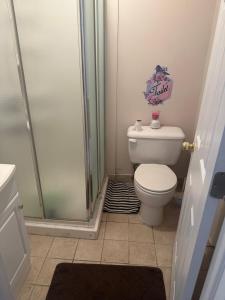 a small bathroom with a toilet and a shower at Cute 2 beds room , for females only in Ottawa