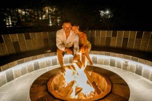 a man and a woman sitting around a fire pit at The Bellwood Manor in Nuwara Eliya
