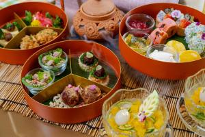 a table topped with bowls of different types of food at Hotel Indigo Bangkok Wireless Road, an IHG Hotel in Bangkok