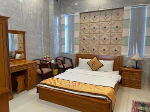 a bedroom with a bed and a desk and a mirror at Hồng Nhung Hotel Kiên Giang in Rạch Giá