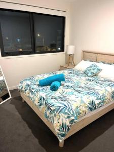 a bedroom with a bed with blue sheets and a window at Casa De Mork - Entire 3 Storey Beach Villa in Gold Coast