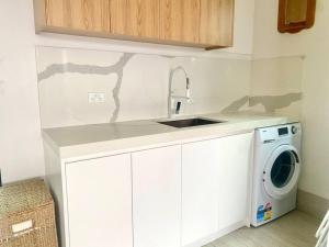 uma cozinha com um lavatório e uma máquina de lavar roupa em Casa De Mork - Entire 3 Storey Beach Villa em Gold Coast