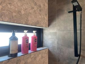 Deux bouteilles de savon sur une étagère dans une salle de bains dans l'établissement Casa De Mork - Entire 3 Storey Beach Villa, à Gold Coast