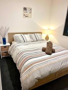 una cama con un animal de peluche sentado encima en Casa De Mork - Entire 3 Storey Beach Villa en Gold Coast