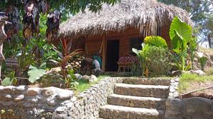 eine kleine Hütte mit einer Steinmauer davor in der Unterkunft ECOCABAÑAS DIOSA JAGUAR tayrona in Santa Marta