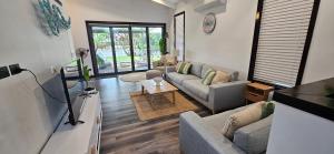 A television and/or entertainment centre at MOOLOOLABA CANAL HOME - Modern 4Bedroom with Spa, Sauna and Private Pontoon - NEW proprietor 2024