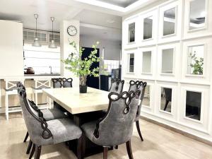 a dining room with a table and chairs and a clock at Modern 4BR Melawati Mall, KL EastMall, Zoo Negara, UIA IIUM in Kuala Lumpur