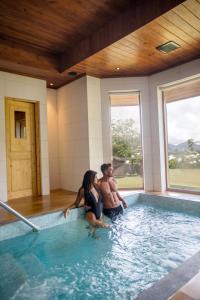 a man and a woman sitting in a swimming pool at The Bellwood Manor in Nuwara Eliya