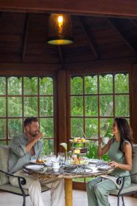 a man and a woman sitting at a table at The Bellwood Manor in Nuwara Eliya