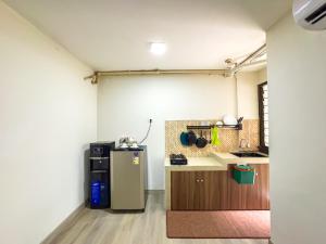 a kitchen with a refrigerator in a room at Beranda Istirahat 2BR Laguna Pluit in Jakarta