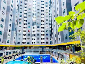 un gran edificio con una piscina frente a él en Beranda Istirahat 2BR Laguna Pluit en Yakarta