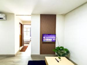 a living room with a tv on a wall at Beranda Istirahat 2BR Laguna Pluit in Jakarta