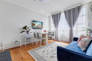 Miracle Miranda Sydney Apartment في ميراندا: غرفة معيشة مع أريكة زرقاء وطاولة