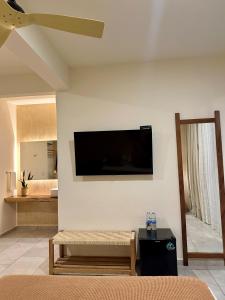 a living room with a flat screen tv on the wall at Casa Bicachi - Adults Only in Puerto Escondido