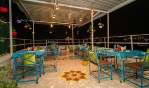 a restaurant with blue tables and chairs on a balcony at Soham Haveli Udaipur in Udaipur