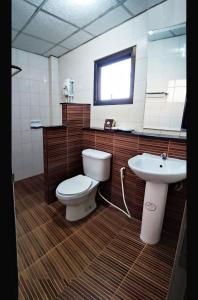 La salle de bains est pourvue de toilettes et d'un lavabo. dans l'établissement โรงแรมอารีน่ารีสอร์ท อุตรดิตถ์, à Uttaradit