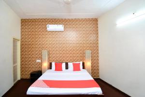 een slaapkamer met een groot bed met rode kussens bij Super OYO Urban Guest House in Patiala